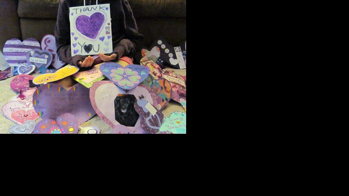 
In this June 19 photo provided by Dana Hoffmann, a 12-year-old Waukesha, Wis., girl who wished to remain unidentified held a thank-you poster for the many supporters from around the world who have sent her cards. The girl, stabbed 19 times in the legs, arms and torso, is making steady physical and emotional progress.
