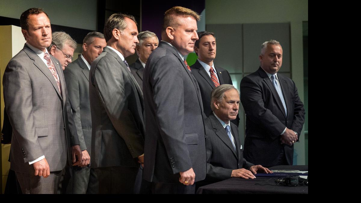 
Texas Gov. Greg Abbott, seated, is flanked by Republicans from the Texas Senate and House of Representatives after signing a franchise tax cut Monday
