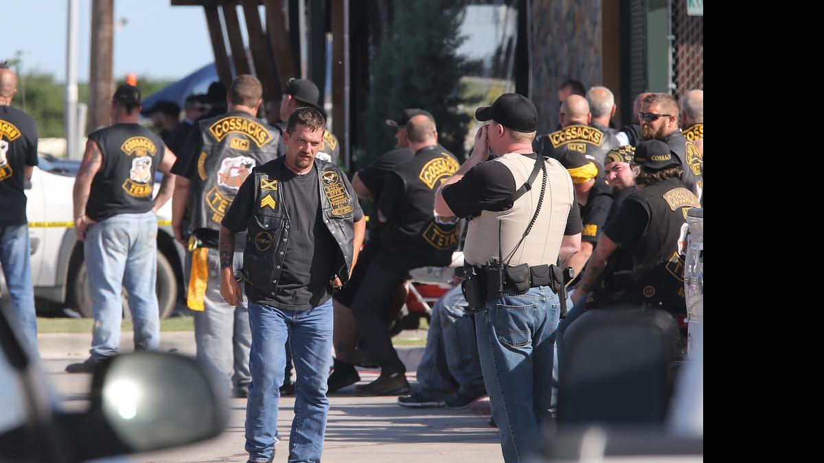 
People stand as officers investigate a shooting in the parking lot of the Twin Peaks restaurant Sunday in Waco, Texas.
