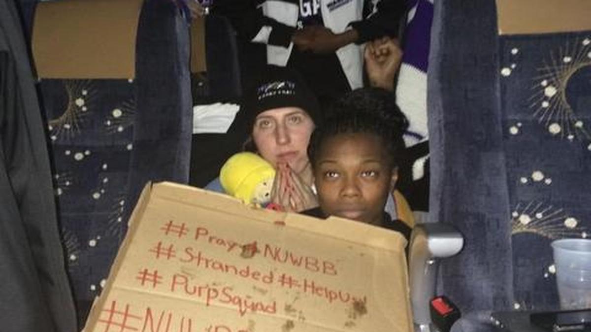 
This photo provided by Chelsea Andorka, the Niagara University women’s basketball team spokeswoman, shows the team holding a sign while their bus was snowbound on the New York State Thruway 
