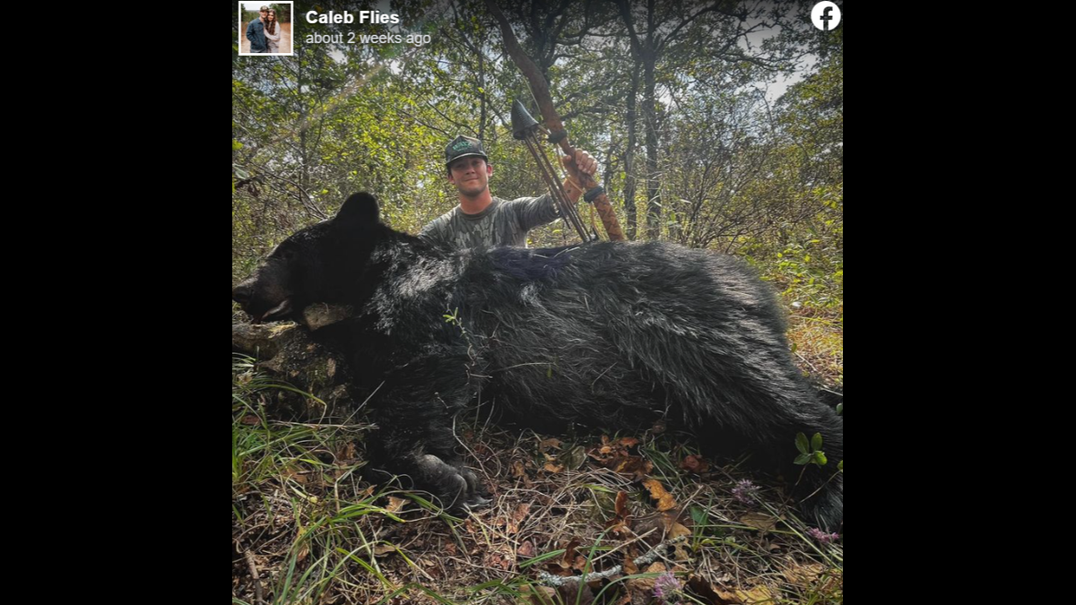 Caleb Flies posing with the black bear he bagged in southeastern Oklahoma.
