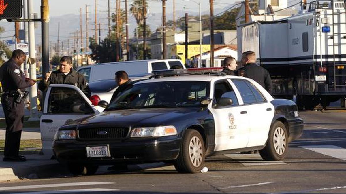
Los Angeles police officers investigate a shooting in South Central Los Angles on Monday, Dec. 29, 2014. A man fired a rifle at two Los Angeles officers in a patrol car on Sunday night but no one was injured.
