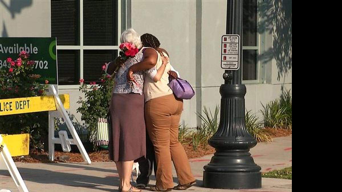 In this image taken from video on Thursday, June 18, 2015, Martha Watson, left, and Tarsha Moseley embrace at a makeshift memorial near Emanuel AME Church in Charleston, S.C. A white man opened fire during a prayer meeting inside the historic black church Wednesday night, killing several people. The shooter remained at large Thursday morning.