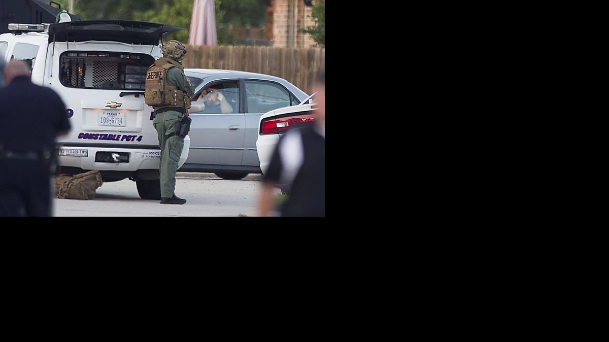 
Law enforcement officers surround a shooting suspect in his car Wednesday, July 9, 2014, in Spring, Texas. 
