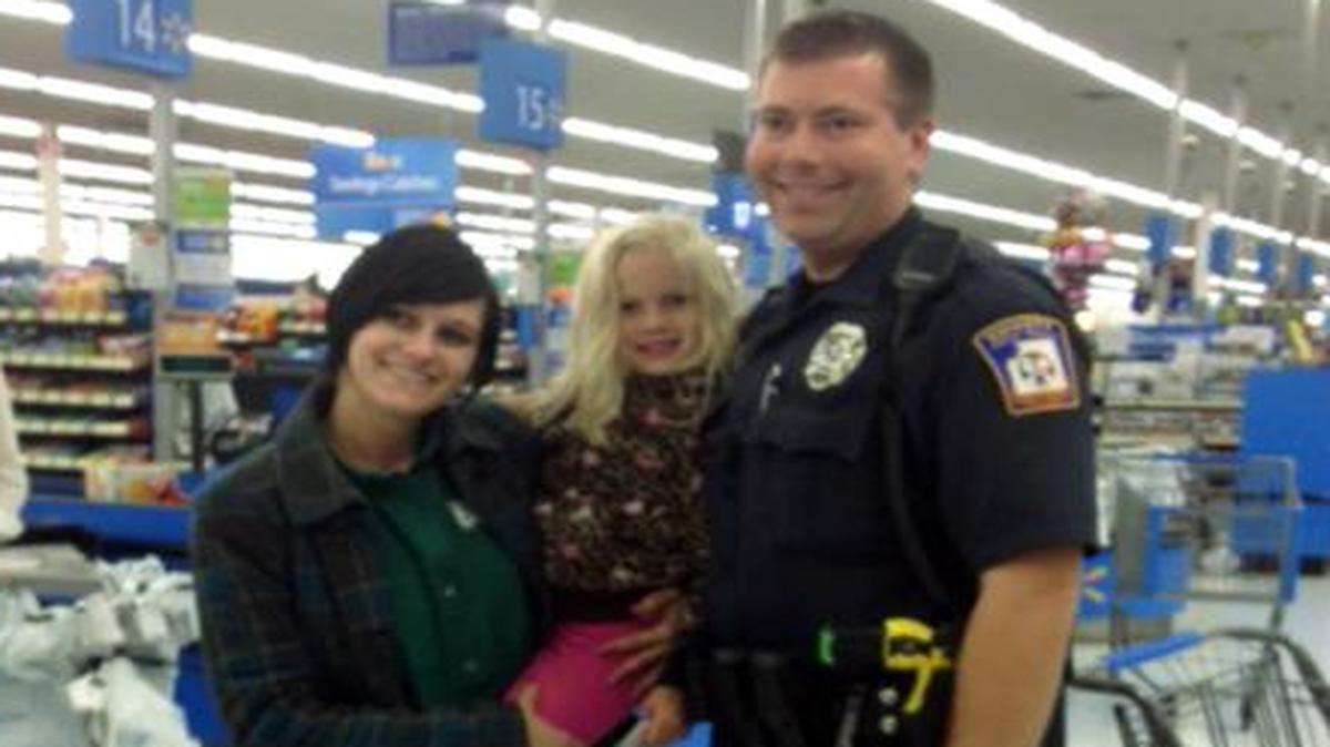 
Emmett Township, Mich., Department of Public Safety Officer Ben Hall, right, with Alexis DeLorenzo, her daughter and the child's seat he bought for them.
