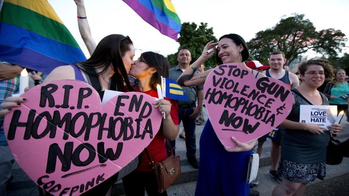 Rachel Henry (left) and Selene Arciga kissed to show their solidarity with members and supporters of the LGBT community gathered Sunday for a candlelight vigil in front of the White House in support for the victims of the massacre at an Orlando nightclub.