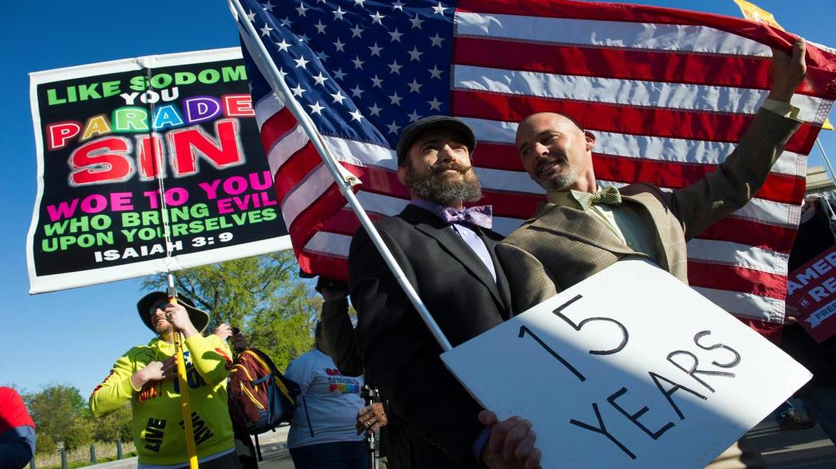 
Same-sex marriage opponents joined supporters, including Joe Capley-Alfano (center) and his husband, Frank Capley-Alfano, in front of the Supreme Court on Tuesday in Washington. The Capley-Alfanos have been together 15 years. 
