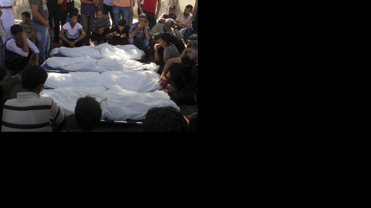 
Palestinian relatives mourn over bodies of 10 members of the Al Astal immediate and extended family, killed by an Israeli strike early at their houses, during their funeral in Khan Younis, in the southern Gaza Strip, Wednesday, July 30, 2014. 
