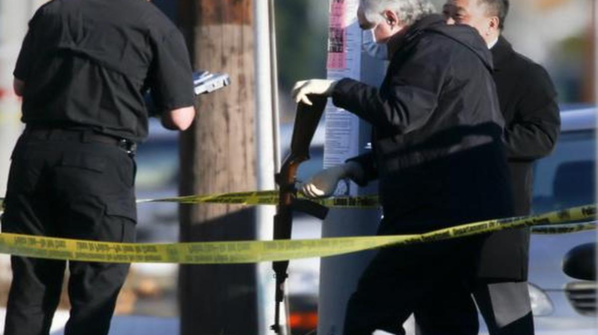 
Investigators recover a rifle found in south Los Angeles on Monday, Dec. 29, 2014, near where two LAPD officers responding to a call received gunfire.
