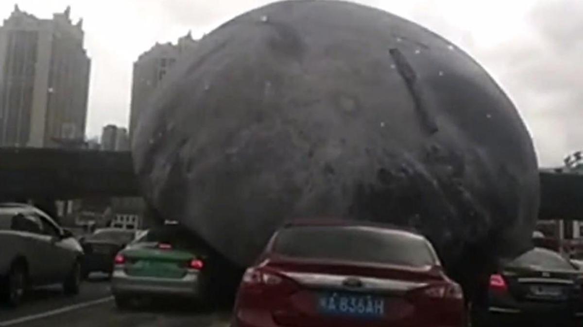 A video posted to Twitter early Wednesday morning shows a humongous moon-shaped balloon rolling like a big fat blob through the Chinese city of Fuzhou.