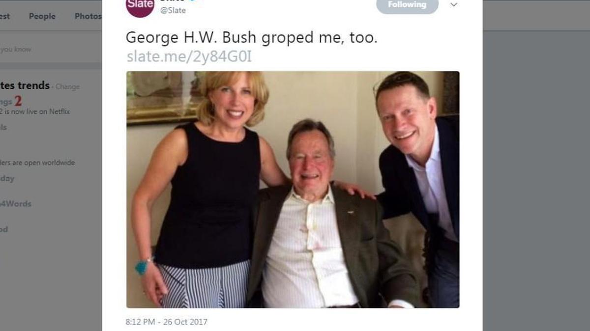 Writer Christina Kline and her husband pose with George H.W. Bush for a photo in 2014. Kline wrote in Slate that Bush “squeezed my butt, hard” as the photo was taken.