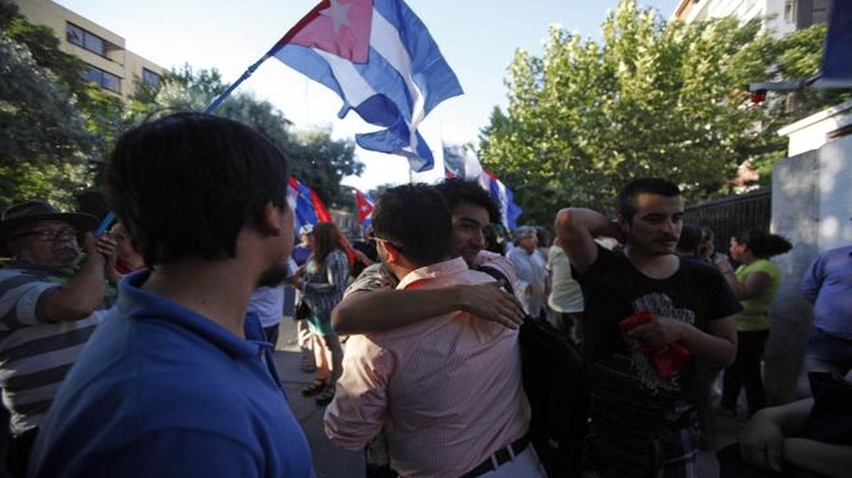 
People celebrated the restoration of diplomatic relations between Cuba and the United States on Wednesday outside of the Cuban Embassy in Santiago, Chile.
