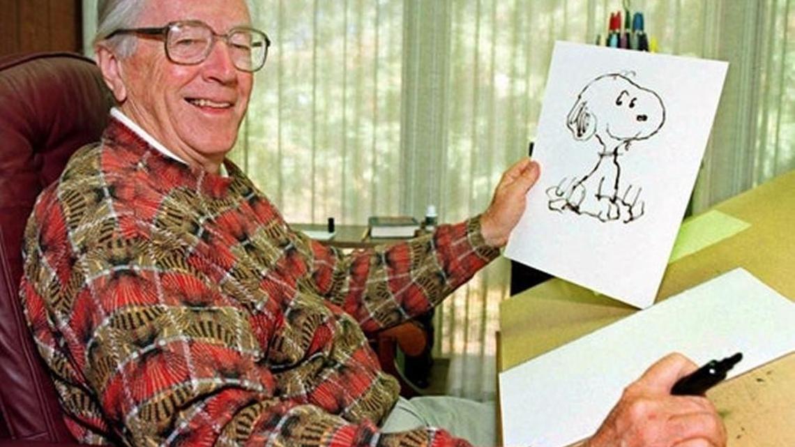 In this Feb. 12, 2000, file photo, cartoonist Charles Schulz displays a sketch of his beloved character “Snoopy” in his office in Santa Rosa, Calif.