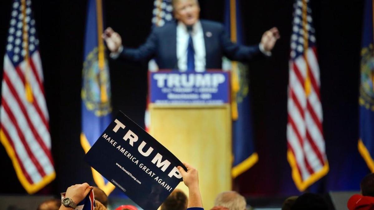 A supporter holds up a sign as Republican presidential candidate Donald Trump addresses the crowd during a campaign rally Monday in Manchester, N.H.