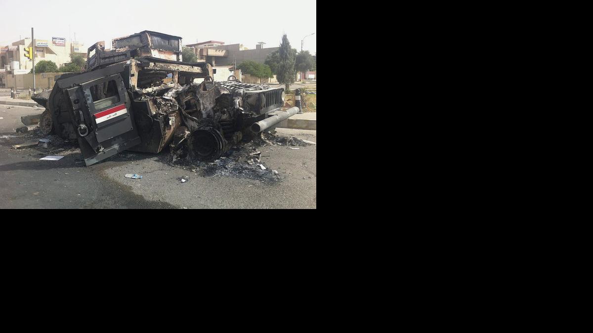 
An Iraqi army armored vehicle is seen burned on a street of the northern city of Mosul, Iraq, on Thursday.

