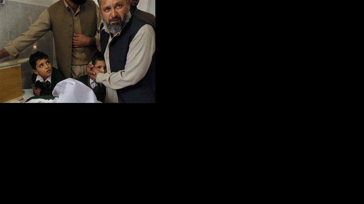 
A Pakistani man comforts a student standing at the bedside of a boy who was injured in a Taliban attack on a school, at a local hospital in Peshawar, Pakistan, Tuesday, Dec. 16, 2014. Taliban gunmen stormed a military-run school in the northwestern Pakistani city of Peshawar on Tuesday, killing and wounding scores, officials said, in the worst attack to hit the country in over a year.(AP Photo/Mohammad Sajjad)
