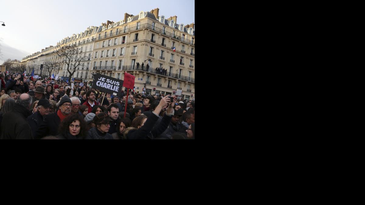 
Thousands of people wave national flags and hold placards that read "I am Charlie" at the Place de la Nation in Paris Sunday
