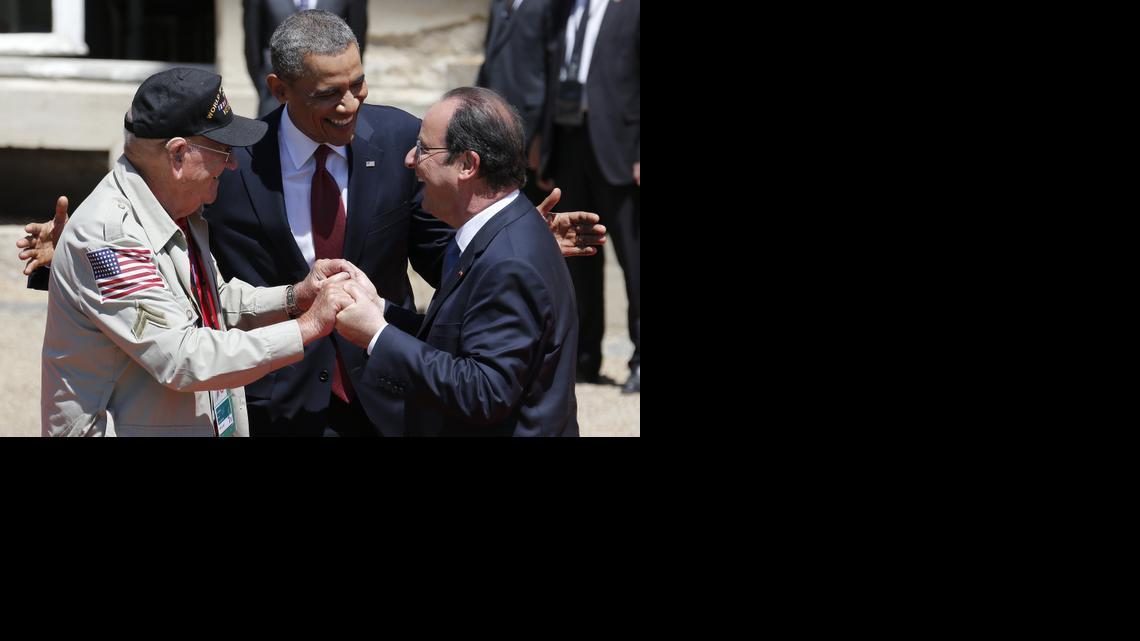
U.S. President Barack Obama, center, and French President Francois Hollande, right, smile next to World War II veteran Kenneth "Rock" Merritt as they arrive for the official lunch at Benouville castle, in Normandy, France, Friday, June 6, 2014. World leaders and veterans paid tribute on the 70th anniversary of the World War Two D-Day landings to soldiers who fell in the liberation of Europe from Nazi German rule, as host France sought to use the event to achieve a thaw in the Ukraine crisis. 
