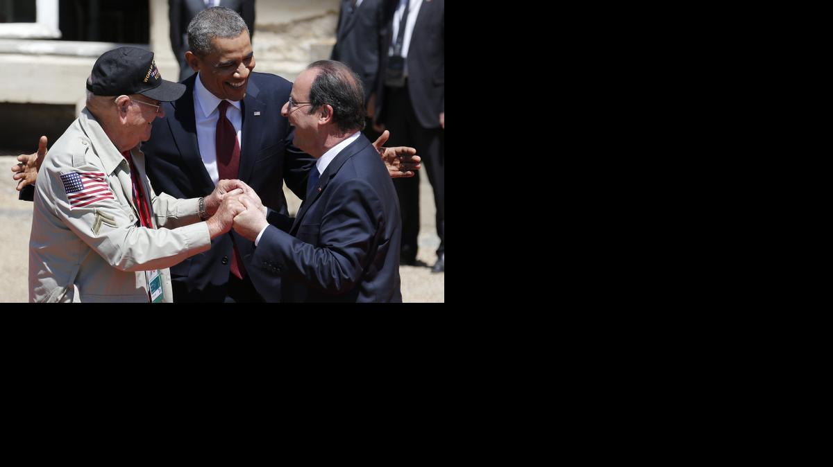
U.S. President Barack Obama, center, and French President Francois Hollande, right, smile next to World War II veteran Kenneth "Rock" Merritt as they arrive for the official lunch at Benouville castle, in Normandy, France, Friday, June 6, 2014. World leaders and veterans paid tribute on the 70th anniversary of the World War Two D-Day landings to soldiers who fell in the liberation of Europe from Nazi German rule, as host France sought to use the event to achieve a thaw in the Ukraine crisis. 
