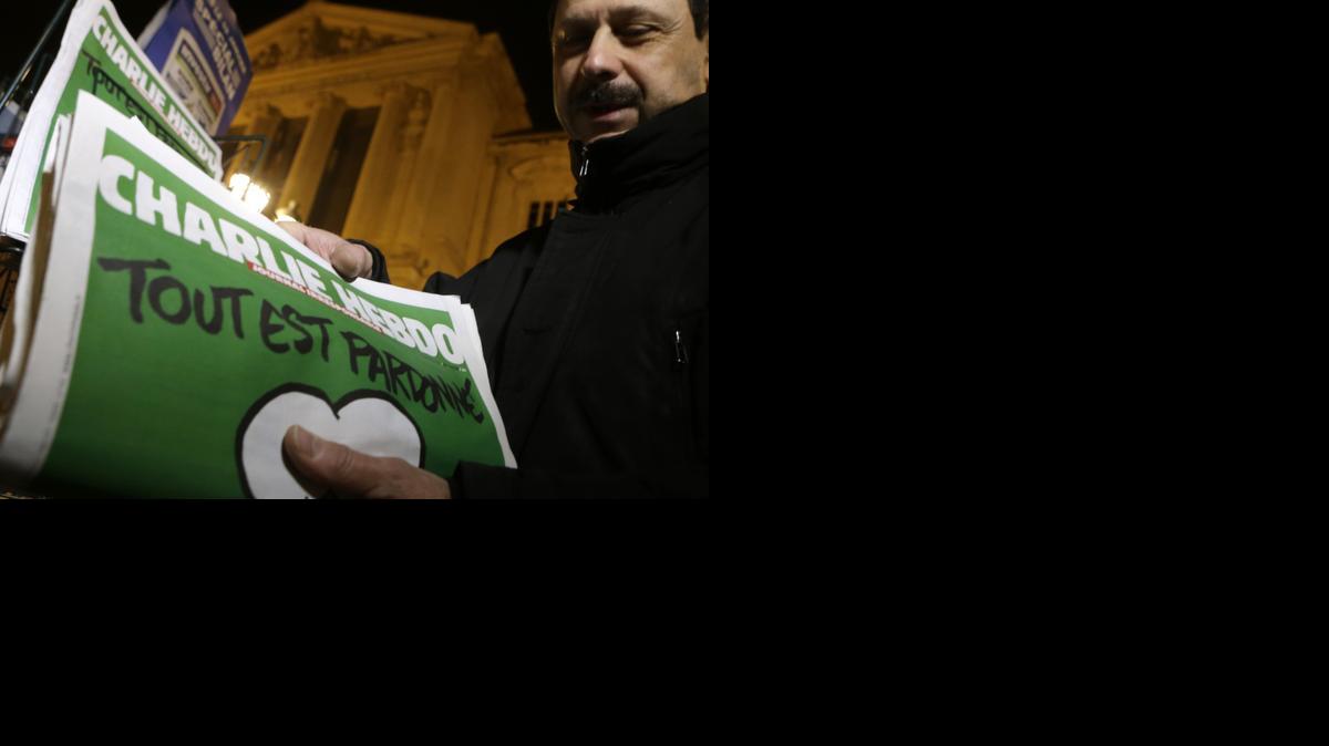 
A newspaper seller installs Charlie Hebdo newspapers on a shelf at a newsstand in Nice, southeastern France
