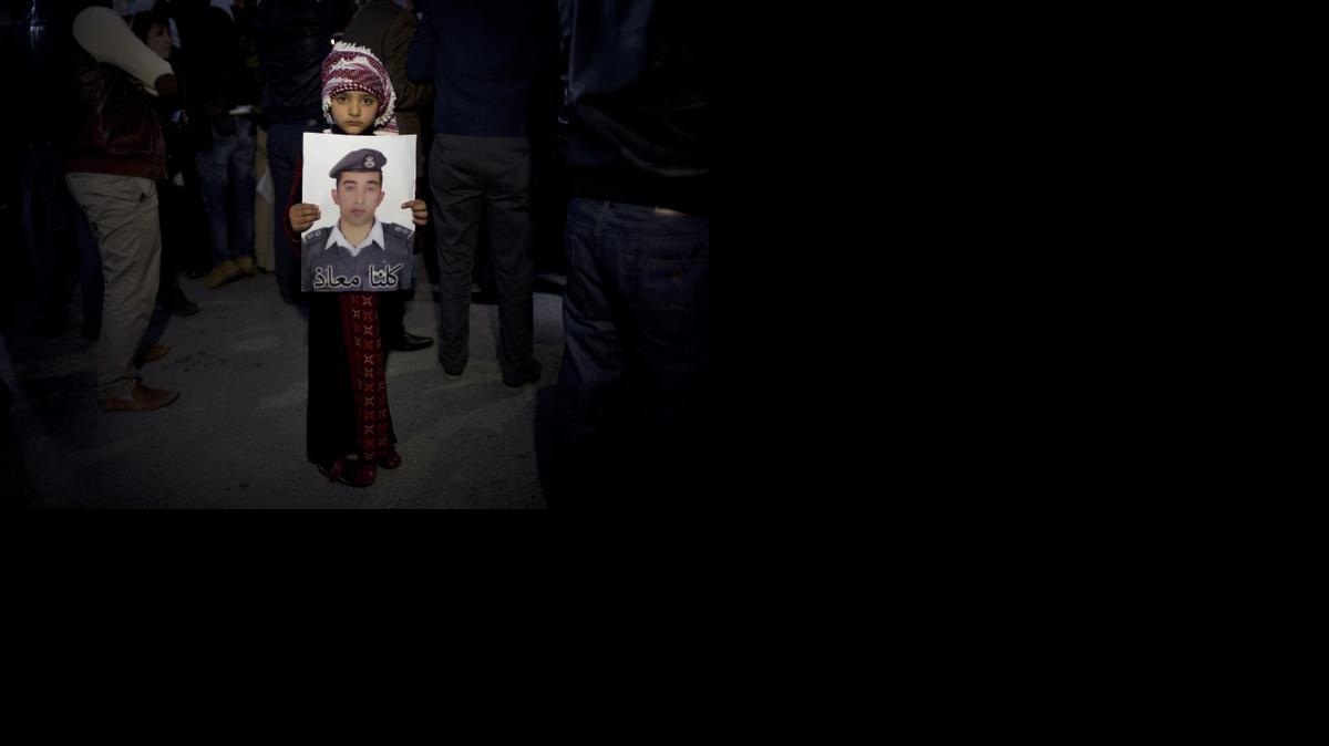 
A Jordanian child on Monday holds a poster with a picture of Jordanian pilot Lt. Muath al-Kaseasbe 
