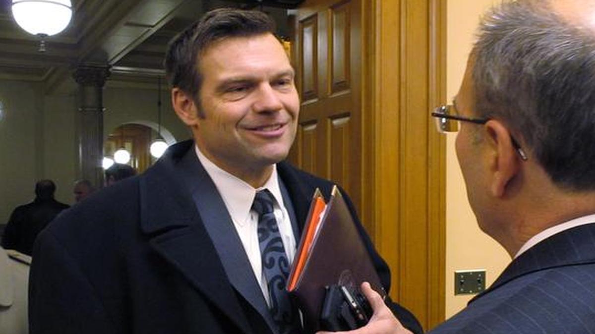 
Kansas Secretary of State Kris Kobach, left, talks with state Rep. Mark Kahrs, right, a Wichita Republican, following a hearing on proposals to change how state Supreme Court justices are selected
