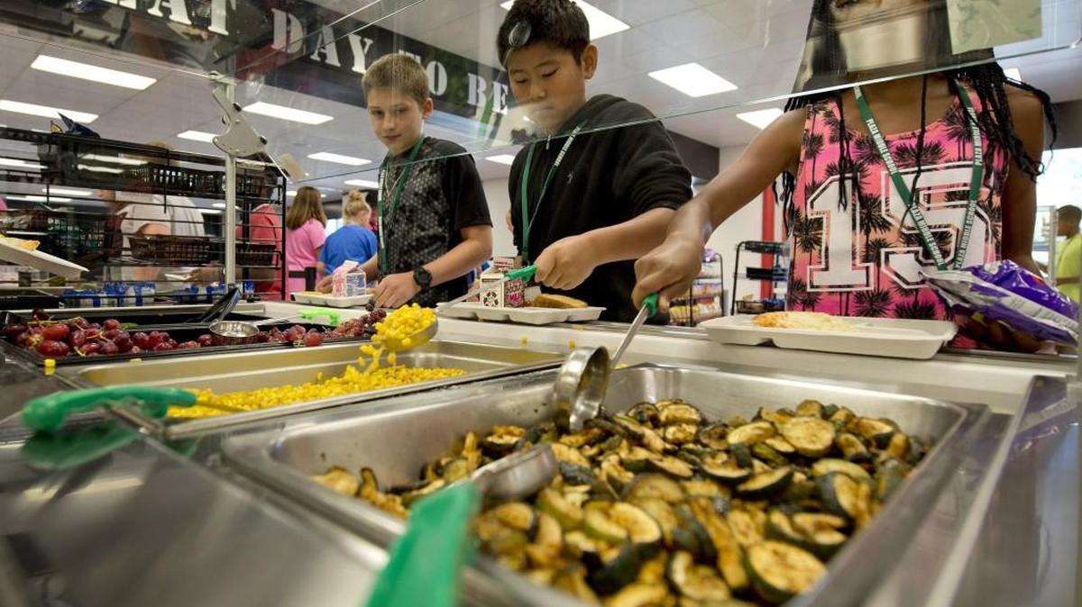 
The lunch program at Plaza Middle School in Kansas City features a variety of healthy offerings. On Thursday, students Garrett Winheim (from left), Evan Nguyen and Laniya Harris selected from items on the vegetable bar that included local organic zucchini, corn, grapes and a mixed salad.
