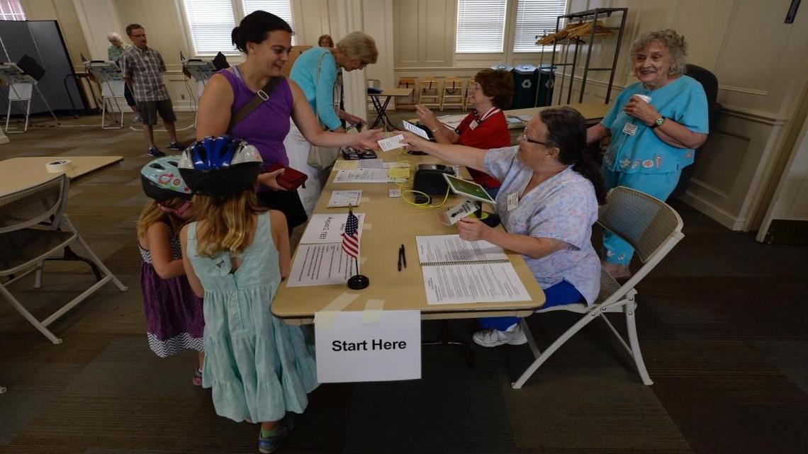 Election worker Ina Allen (seated, right) handed a ballot ticket to Emily Wiebe of Prairie Village on Tuesday morning August 2, 2016, as Wiebe voted at Asbury Methodist Church, 5400 W. 75th St.