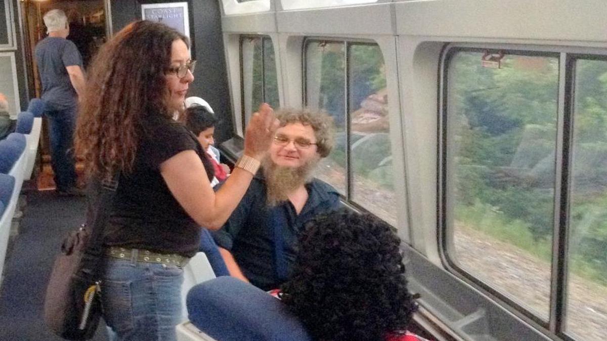 ​The woman in the observation car of the Southwest Chief is the wife of a corrections officer. She speaks with an Amish man. Those on the Amtrack train reflect the diversity of America that’s passing by.