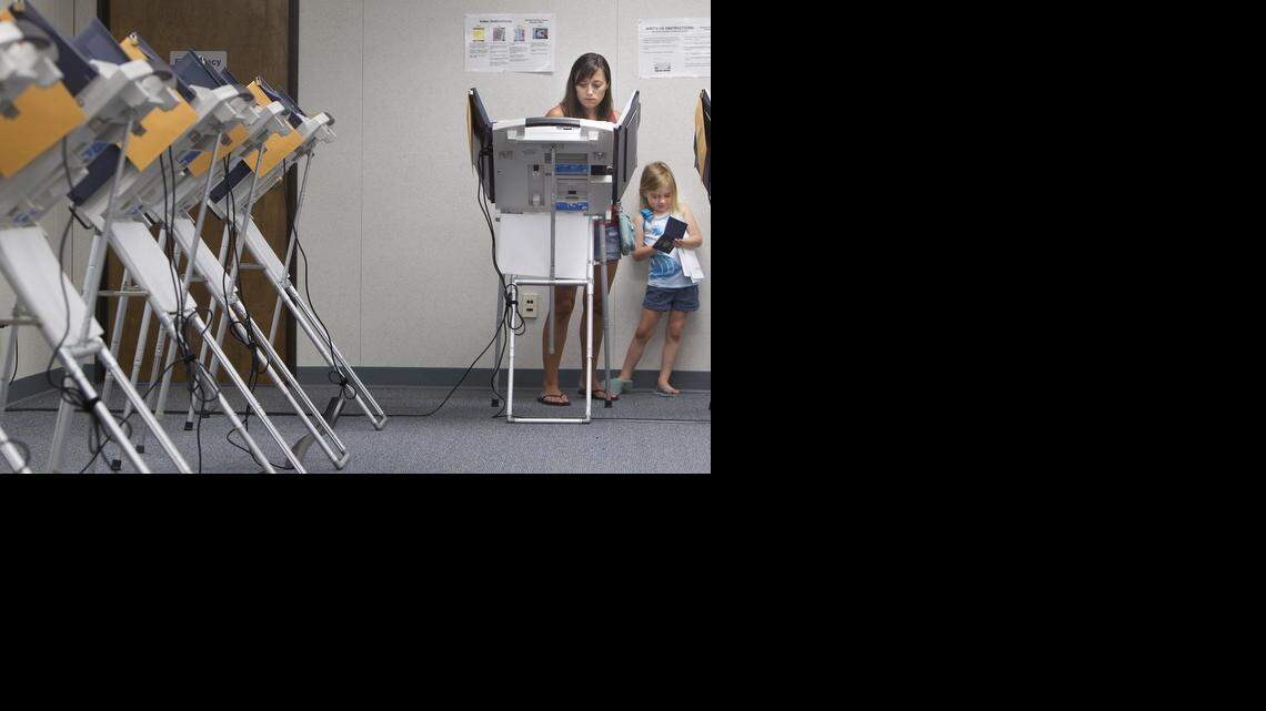 
Kansas voter Jennifer Ford of Olathe cast an early ballot as her daughters Jaelynn, 5, (right) and Juneau Ford, 2, (not in photo) waited for her to finish her civic duty on Monday, Aug. 4, 2014, during Early Voting at Johnson County Election Office, 2101 East Kansas City Rd., in Olathe. On Tuesday, polls in Kansas will be open from 7 a.m. to 7 p.m., while Missouri polling places will be open from 6 a.m. to 7 p.m.
