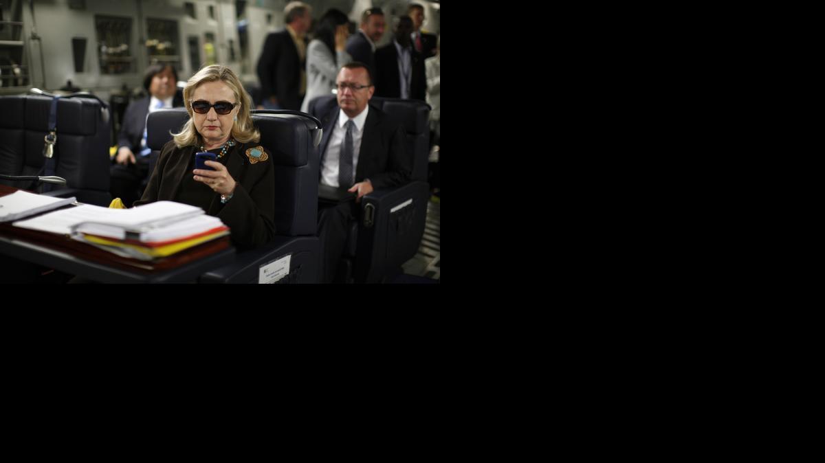 
Then-Secretary of State Hillary Rodham Clinton checks her Blackberry from a desk inside a C-17 military plane in 2011
