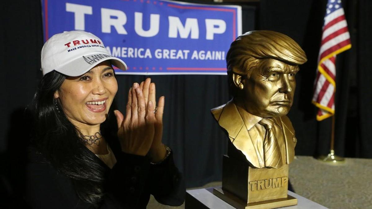 Angelina Sobannarath cheers next to a golden bust of Donald Trump during a watch party at the Corey Center in Atlanta on Tuesday, March 1, 2016.
