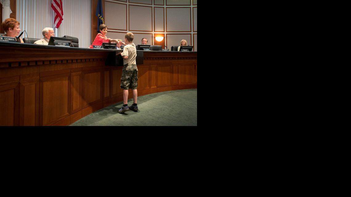 
Spencer Collins, 9, got a handshake and a book from Mayor Peggy Dunn on Monday night after the Leawood City Council unanimously approved a temporary exemption for “Little Free Libraries” such as his from an ordinance that prohibits structures in front yards.
