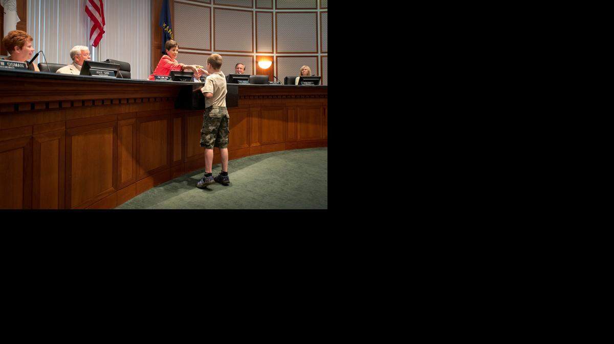 
Spencer Collins, 9, got a handshake and a book from Mayor Peggy Dunn on Monday night after the Leawood City Council unanimously approved a temporary exemption for “Little Free Libraries” such as his from an ordinance that prohibits structures in front yards.

