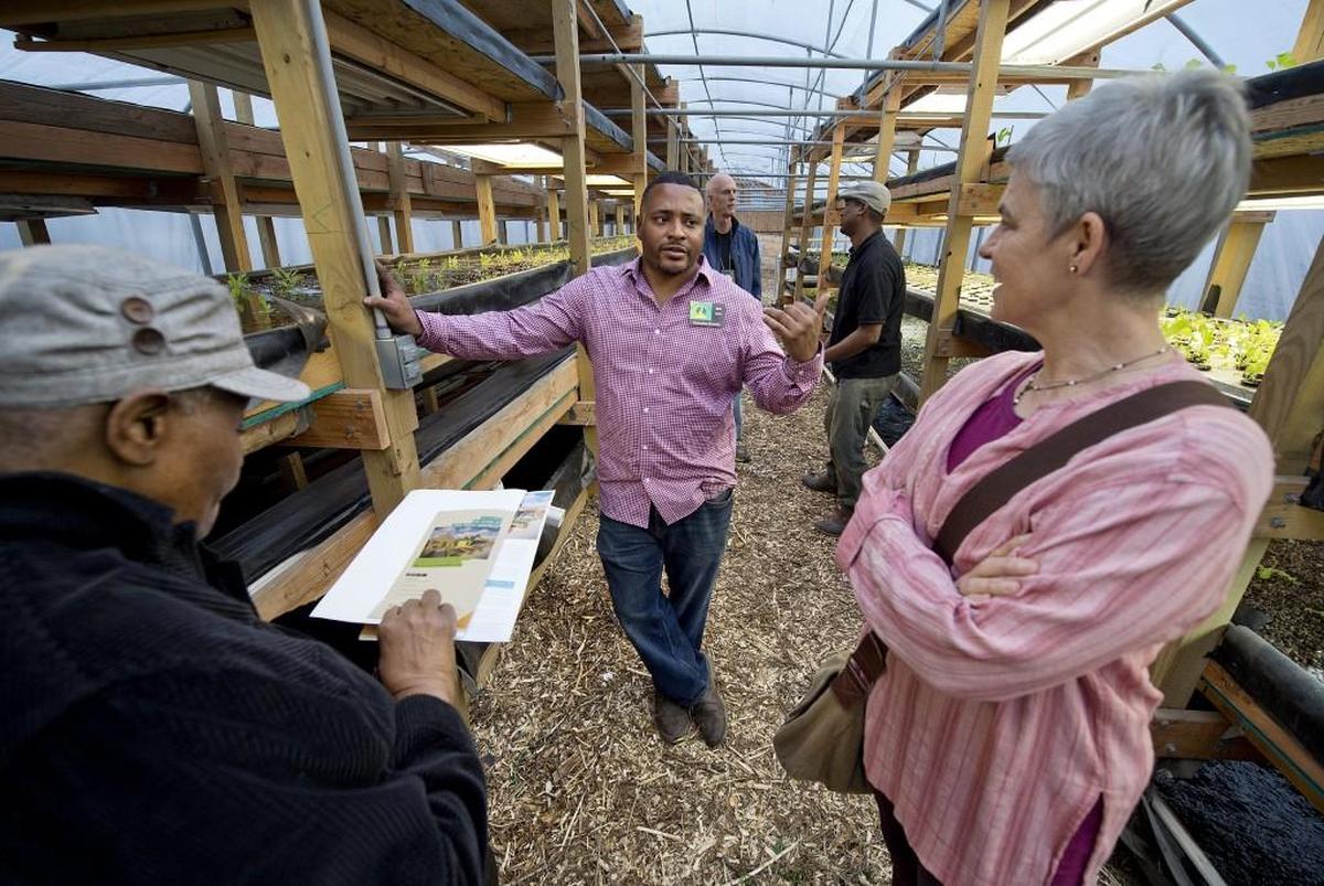 Dre Taylor (center), founder of Nile Valley Aquaponics, talked with Ruby Berry (left) and Jeanne Johnson on Friday, March 24, 2017, at a ribbon cutting celebration for the facility at 2905 Wabash Avenue.