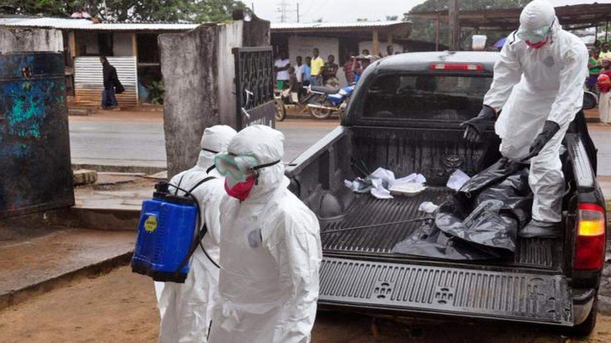 
Health workers in protective gear moved the body of a dead person onto the back of a truck Tuesday in Monrovia, Liberia. She apparently died of the Ebola virus. The number of Ebola cases in West Africa could start doubling every three weeks, the World Health Organization warned Tuesday.
