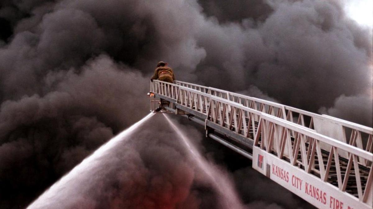 A Kansas City, Kan., firefighter battles a blaze from an aerial ladder truck.