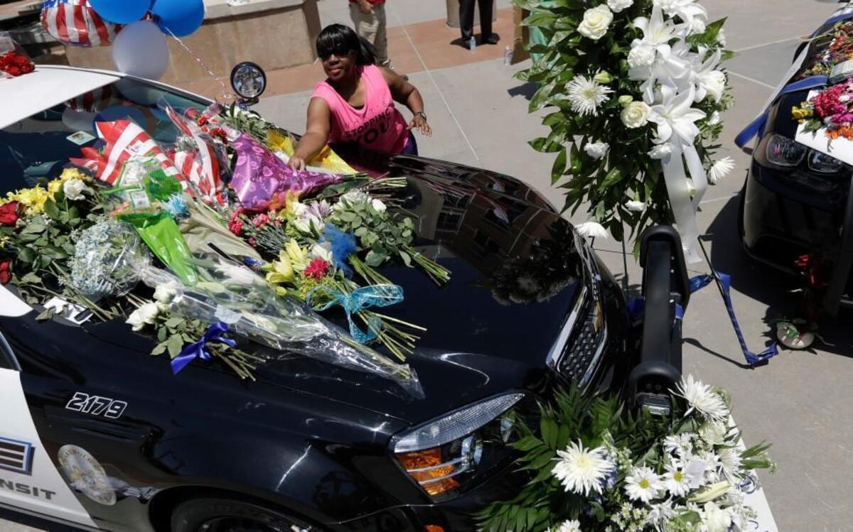 Cynthia Ware placed flowers on a makeshift memorial at Dallas police headquarters Friday.