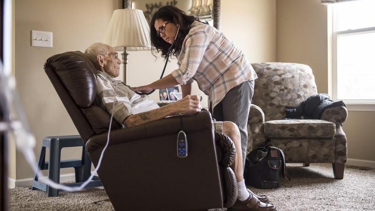 Jennifer Moss, a hospice nurse with Kansas City Hospice, right, takes the vital signs of Al Jensen, 90, of Olathe, who has stomach cancer. Home-care attendants like Moss will not receive wage hikes after the Missouri Legislature overrode Gov. Jay Nixon’s veto on Tuesday.