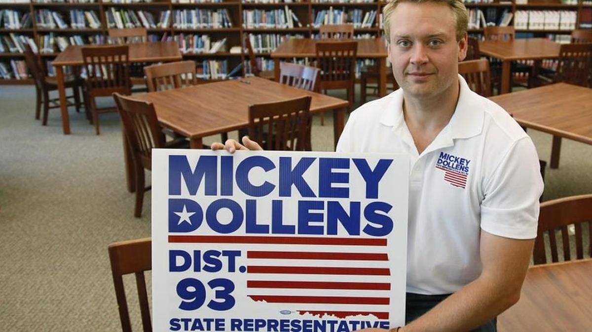 Mickey Dollens with one of his campaign signs in the library at U.S. Grant High School, where he used to teach English, in Oklahoma City, Wednesday. Dollens said he decided to run for the state House in Oklahoma to fix what he saw as problems the GOP-controlled Legislature was inflicting on education. Then the 28-year-old got laid off as a result of state-imposed cuts to public schools.
