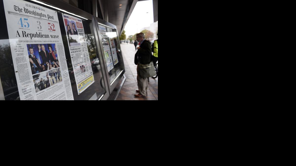
A man looks over the front pages from newspapers around the country 
