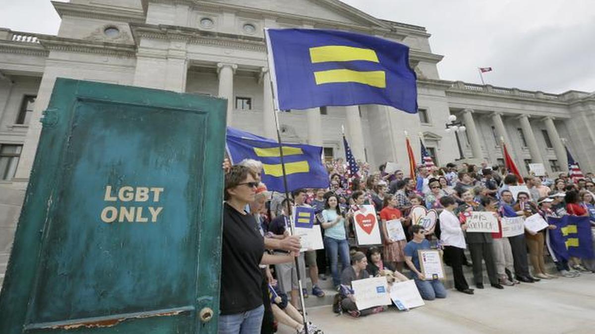 
A painted door, part of artist V.L. Cox's, left, "End Hate" series, is displayed during a rally at the Arkansas state Capitol in Little Rock
