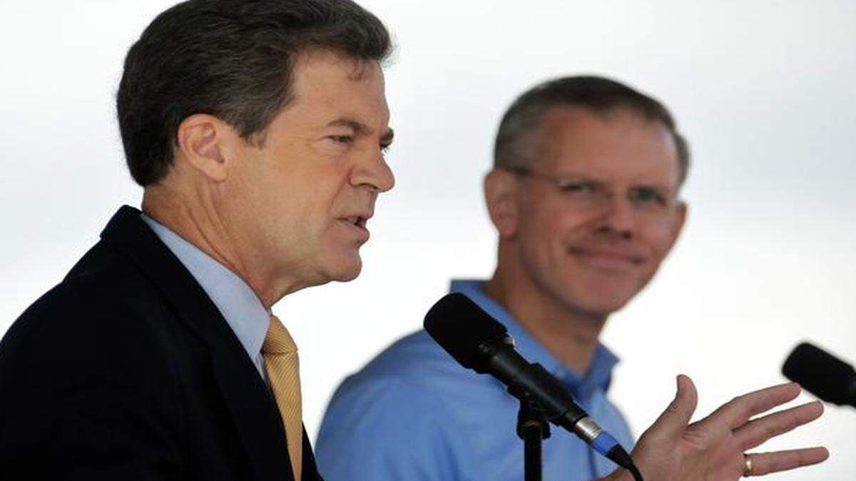 
Republican Gov. Sam Brownback (left) answers a question while his Democratic challenger, Paul Davis, listens during their first debate Saturday at the Kansas State Fair in Hutchinson. 

