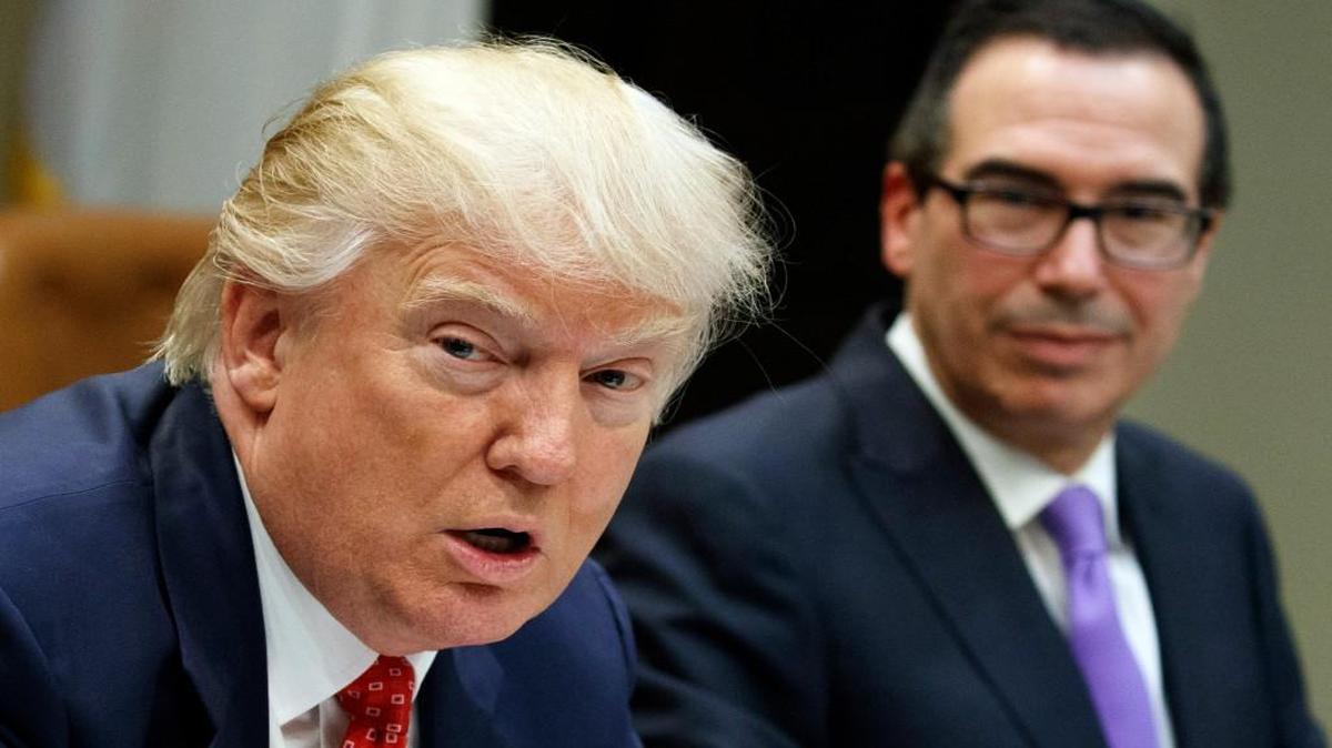 In this Feb. 22 file photo, Treasury Secretary Steven Mnuchin (right) listened as President Donald Trump spoke in a White House meeting on the federal budget. Trump wants to tackle tax reform, but the defeat of his health care reform plan deals a blow to that effort.