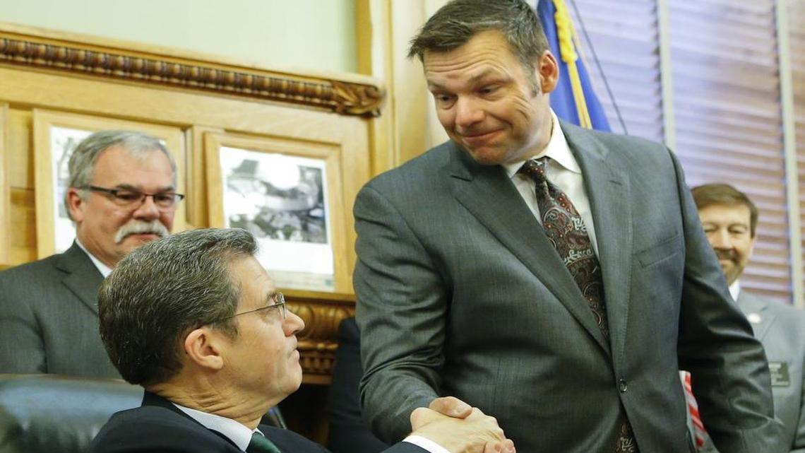 Kansas Secretary of State Kris Kobach shook hands with Gov. Sam Brownback on in June at the Kansas Statehouse in Topeka after Brownback signed Senate Bill 34, which grants prosecuting power to the secretary of state for cases of voter fraud.