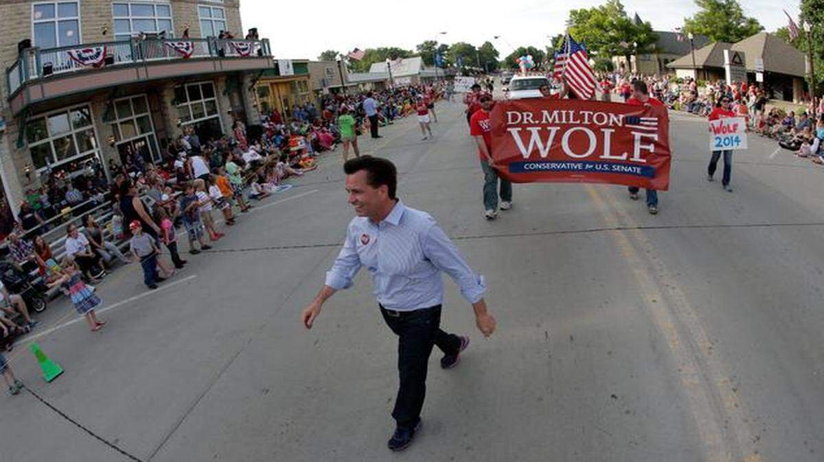 
Milton Wolf works the crowd at a Fourth of July parade in Wamego, Kan. Wolf has tea party backing in his quest to unseat GOP incumbent Pat Roberts.
