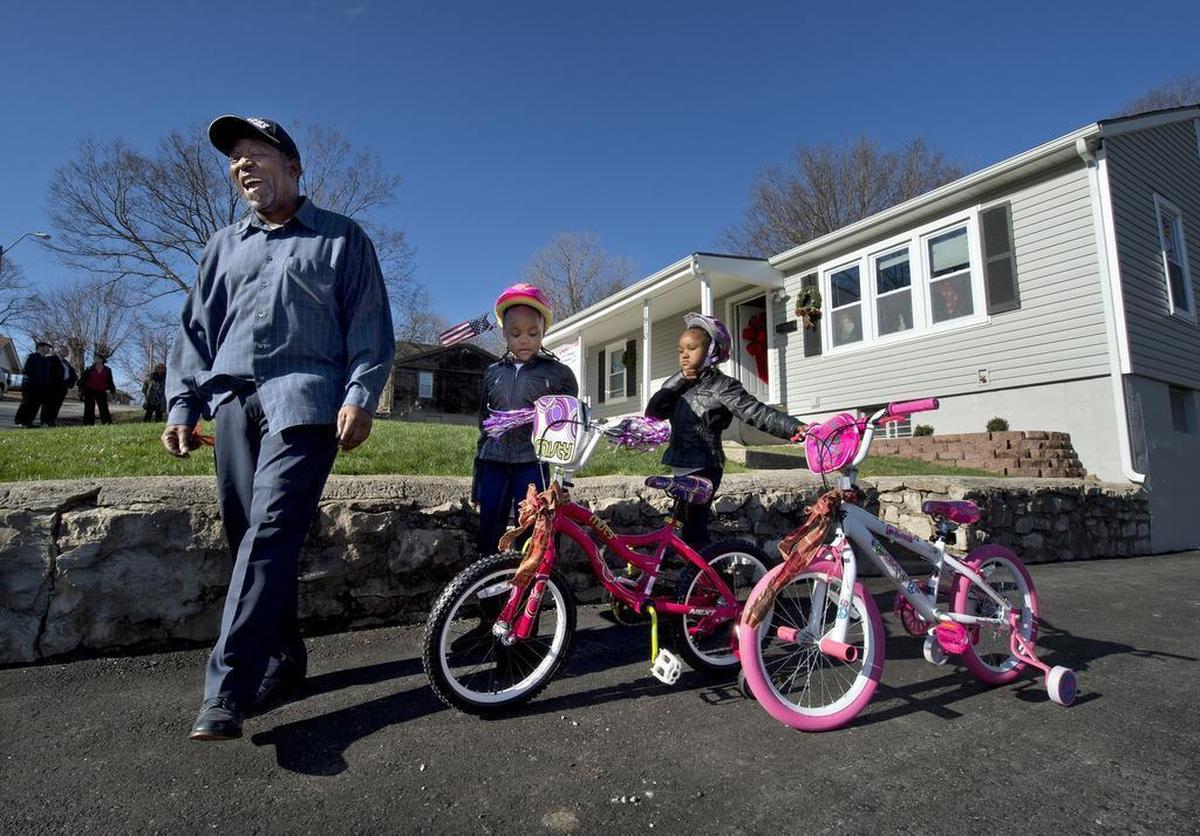 In this file photo from 2015, Artis Rollins and his twin 5-year-old daughters, Ariah (left) and Arielle, stand in front of their renovated home in the Marlborough neighborhood that was part of the Jackson County’s Constructing Futures home giveaway.