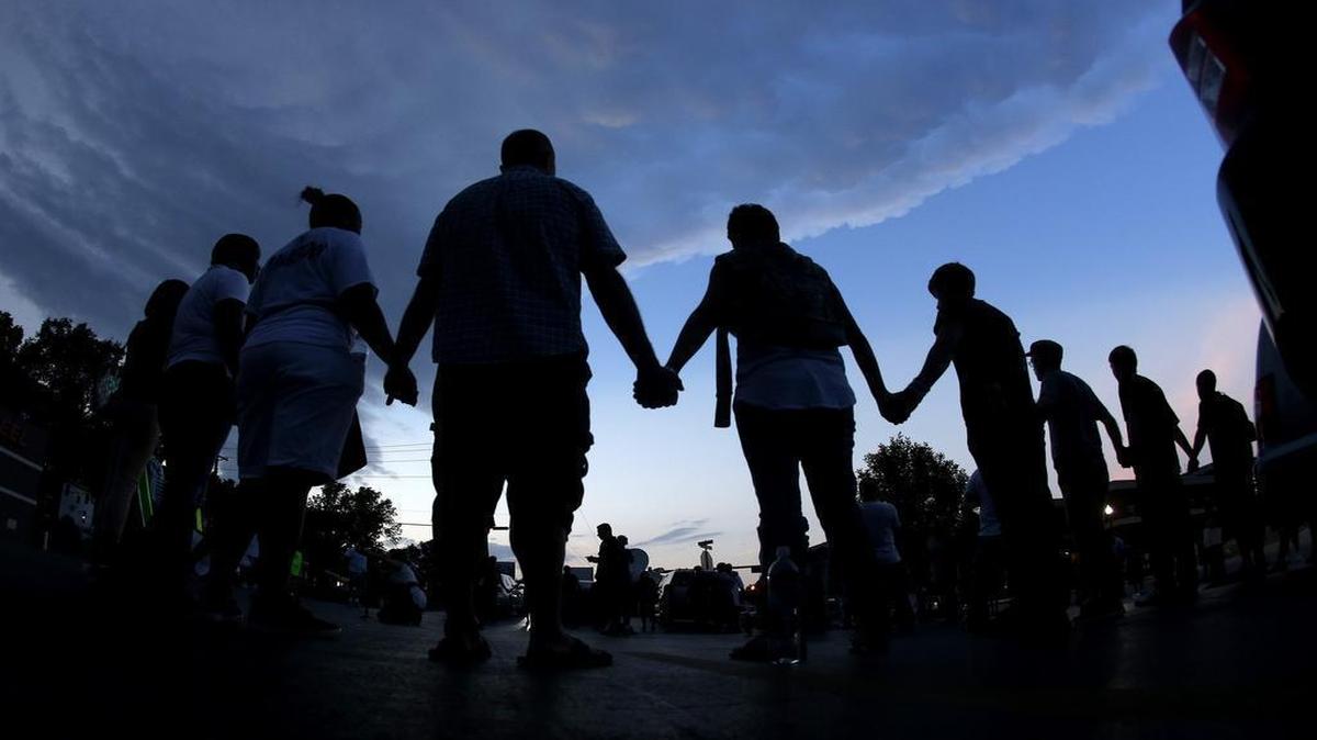 
People stood in prayer last August to protest the death of Michael Brown in Ferguson, Mo. Events are planned for Sunday in Kansas City to mark the anniversary of Brown’s death. 

