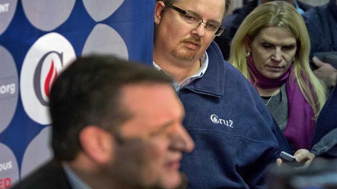 Jeff Roe (top, wearing blue pullover) watched closely as Ted Cruz talked with the media after arriving last week at a campaign event in Winterset, Iowa.