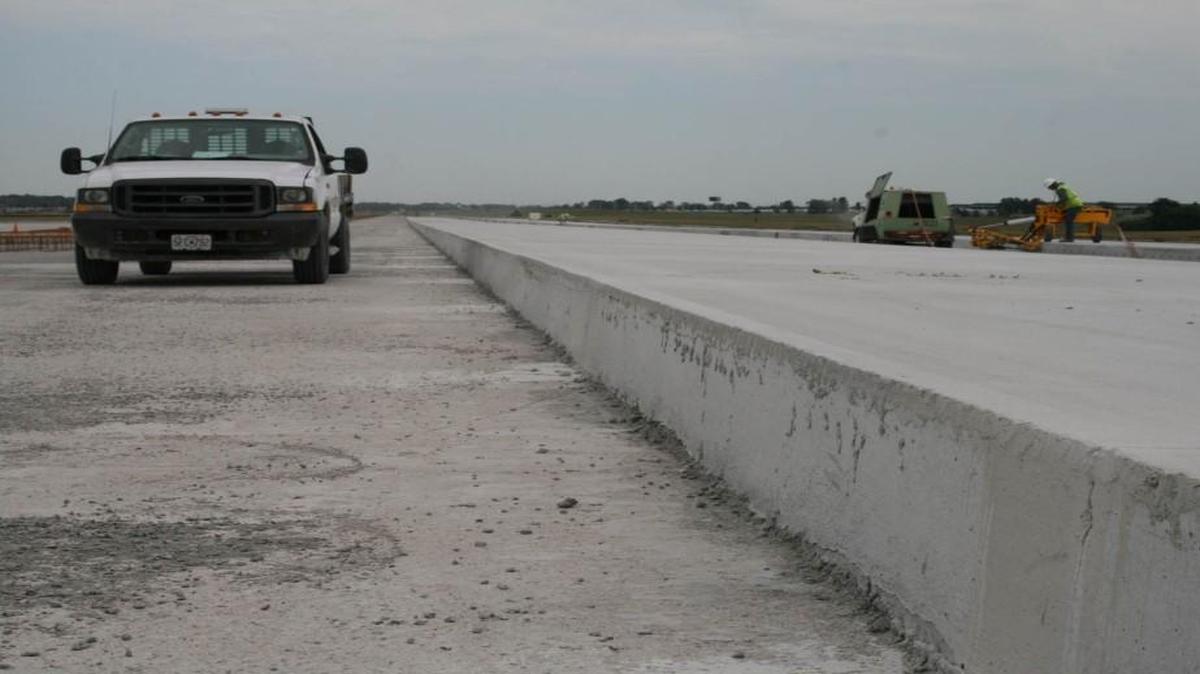 A pickup sits next to a portion of the new 17-inch-thick pavement being installed as part of the first phase of a runway rehabilitation project at Kansas City International Airport.